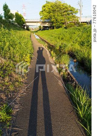 写真を撮っている人の影 77610042