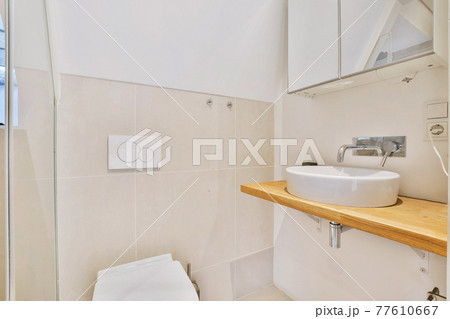 Simple bathroom design with toilet and wooden counter 77610667
