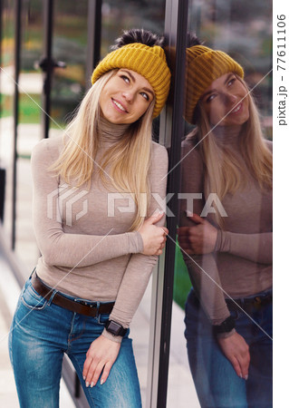 blond lgirl in knitted hat and scarf with coffee paper glass close up portrait in cafe blond lgirl in knitted hat and scarf with coffee paper glass close up portrait in cafe 77611106