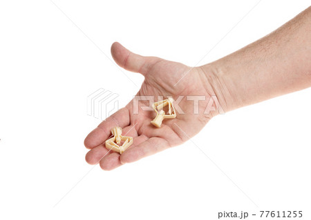 Hand holds a plastic dowel for screws on a white background 77611255