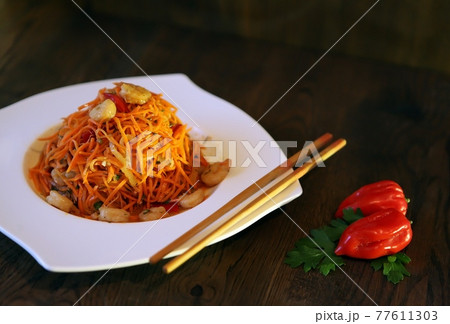 Spicy Korean-style carrot salad on a dark background. Koryo-saram cuisine 77611303