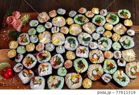 Sushi Set - Different Types of Maki Sushi and Nigiri Sushi. Served on dark wooden table. 77611319