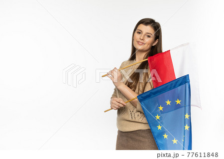 Young girl with the flag of the European Union and Poland. The student is holding two flags in her hand. Woman with flags on white background. 77611848