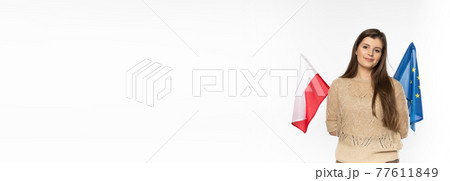 Young girl with the flag of the European Union and Poland. The student is holding two flags in her hand. Woman with flags on white background. Panoramic frame. Young girl with the flag of the European Union and Poland. The student is holding two flags in her hand. Woman with flags on white background. Panoramic frame. 77611849
