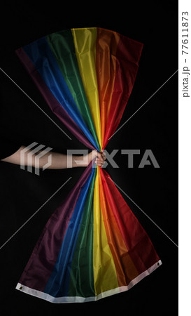 LGBTQ pride flag. Lesbian Gay Bi sexsual Transgender Queer. Homosexsual pride Rainbow flag in gay hand. black background. Represent symbol of freedom, peace, equality and love. LGBTQ concept. 77611873