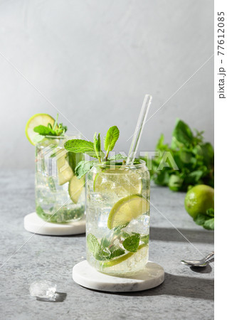 Mojito with lime, mint and ice cube on gray background. 77612085