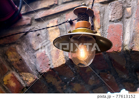 retro street light lantern on brick wall with edison electric lamp, decorative architectural element in old style close-up. 77613152