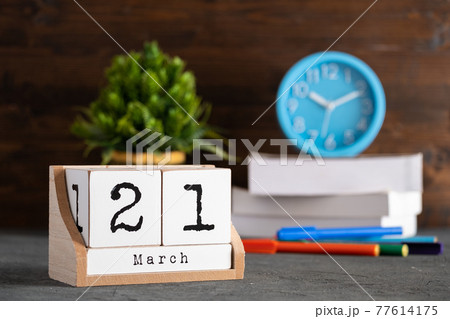 March 21st. March 21 wooden cube calendar with blur objects on background. 77614175