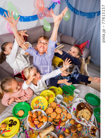 children giving presents to girl during party 77615157