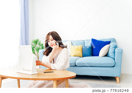 自宅でメイクをする若い女性 自宅でメイクをする若い女性 77616249