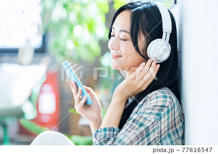 女性 ライフスタイル スマホ ヘッドフォン 音楽 リビング ニューノーマル 女性 ライフスタイル スマホ ヘッドフォン 音楽 リビング ニューノーマル 77616547