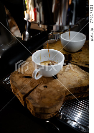 Fresh espresso shot pouring out of machine. 77617801