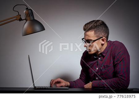 businessman in glasses and a shirt sits at a table with open laptops Coffee Space mobile phone businessman in glasses and a shirt sits at a table with open laptops Coffee Space mobile phone 77618975