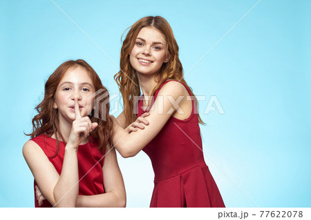 Family mom and daughter hug red dresses communication emotions blue background Family mom and daughter hug red dresses communication emotions blue background 77622078