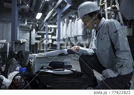 工場を点検する前に図面をチェックする作業員男性 工場を点検する前に図面をチェックする作業員男性 77622822