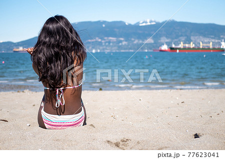 カナダのビーチで対岸を見つめる水着姿の黒人系カナダ人少女の後ろ姿 77623041