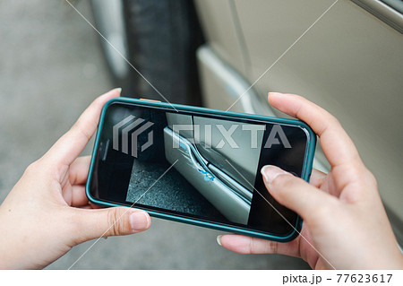Women using a smartphone for taking a photo to send to insurance. Concept of claim insurance for a car accident online after send photo and evidence to the insurance company 77623617