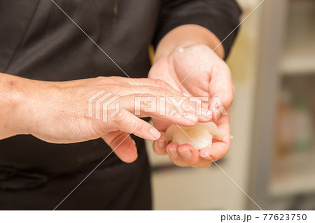 イカの握り寿司を握る寿司職人の手元 イカの握り寿司を握る寿司職人の手元 77623750
