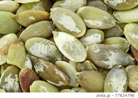 Close-up background texture of green pumpkin seeds. Close-up background texture of green pumpkin seeds. 77624796