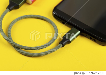 Charging a mobile phone Charging a mobile phone 77624799