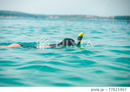 woman in snorkeling mask in sea water 77625907