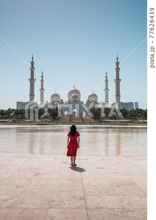 Woman enjoying view of Sheikh Zayed Grand Mosque in Abu Dhabi, United Arab Emirates on a sunny day Woman enjoying view of Sheikh Zayed Grand Mosque in Abu Dhabi, United Arab Emirates on a sunny day 77626439