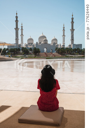 Woman enjoying view of Sheikh Zayed Grand Mosque in Abu Dhabi, United Arab Emirates on a sunny day 77626440