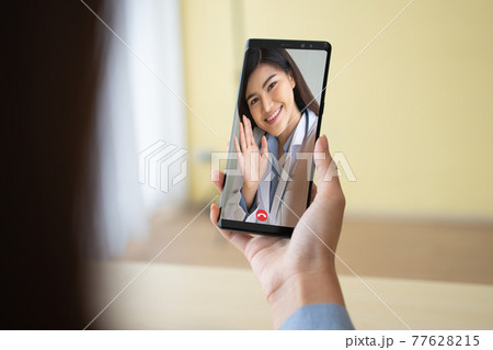 Asian doctor or therapist help relieve stress and provide knowledge and understanding about office syndrome to patients video conference call online live talk remotely at home by smartphone 77628215