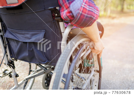 Asia lady woman patient on wheelchair in park Asia lady woman patient on wheelchair in park 77630678