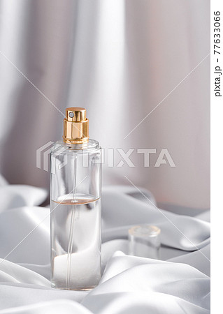 Luxurious perfume bottle on a draped silk fabric in grey tones Luxurious perfume bottle on a draped silk fabric in grey tones 77633066