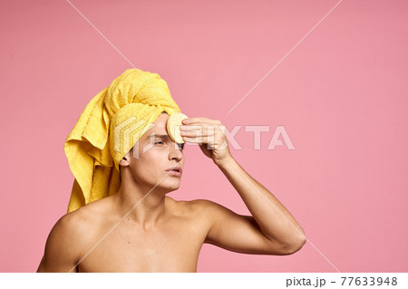 man with a towel on his head and a yellow sponge in his hand cosmetic procedure clean skin of the face man with a towel on his head and a yellow sponge in his hand cosmetic procedure clean skin of the face 77633948