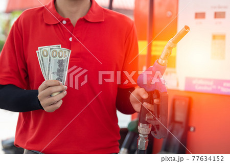 Fuel cost saving concept, staff worker hand holding money cash back at Gas station Fuel cost saving concept, staff worker hand holding money cash back at Gas station 77634152