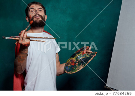 Male artist red cloak drawing easel art green background image 77634269