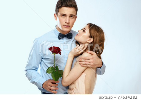 Man and woman with a red rose on a light background love family hugs Man and woman with a red rose on a light background love family hugs 77634282