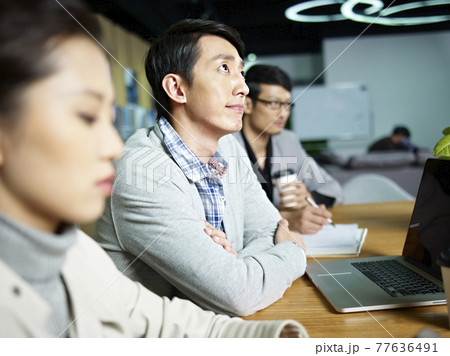 young asian businessman thinking during meeting young asian businessman thinking during meeting 77636491