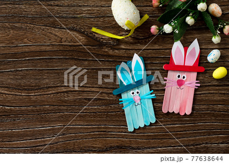 Easter bunny toy gift stics puppets on wooden table. Copy space. Handmade. Project of children's creativity, crafts for kids. 77638644