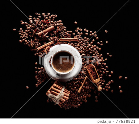 Black coffee in a white cup with coffee beans, cinnamon sticks, and star anise. Black coffee in a white cup with coffee beans, cinnamon sticks, and star anise. 77638921