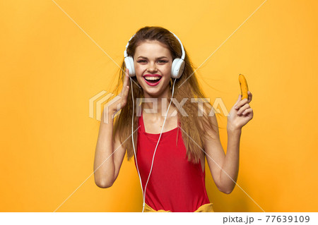 woman in headphones listening to music red t shirt emotions fashion yellow background lifestyle 77639109