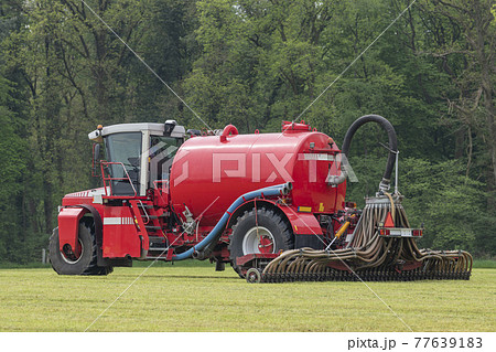 Injecting a freshly mowed lawn with a red injector . Injecting a freshly mowed lawn with a red injector . 77639183