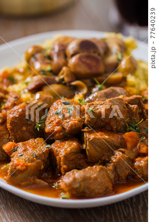 Polenta and beef stew on a plate. High quality photo. Polenta and beef stew on a plate. High quality photo. 77640239