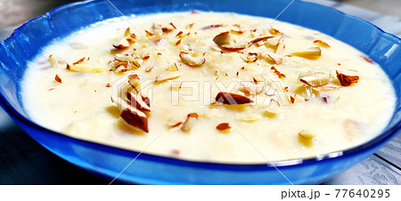 Sweet Rabdi or Lachha Rabri or basundi, made with pure milk garnished with dry fruits. Served in a bowl over moody background. 77640295