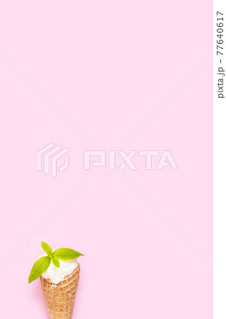 Mint vanilla ice cream with in a waffle cone with mint leaves on pink background. 77640617
