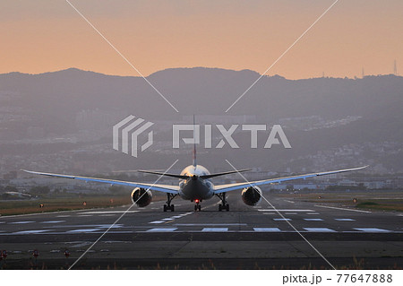 夕景の滑走路でこれから離陸を待つ飛行機の後ろ姿 77647888