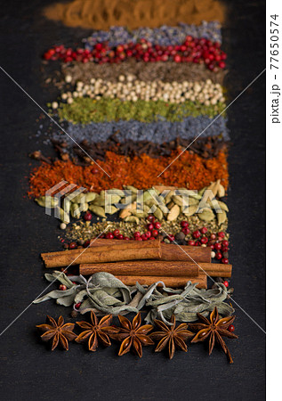 Powder spices on spoons in black wooden table background 77650574