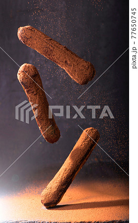 French dessert. Eclair with chocolate icing. Dark background French dessert. Eclair with chocolate icing. Dark background 77650745