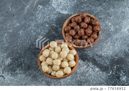 Wooden bowls with sweet corn balls on a gray background 77658952