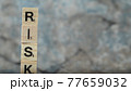 Risk writing with black letters on wooden dices on the marble background 77659032