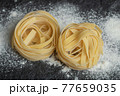 Raw nest noodles with flour on a dark background 77659035