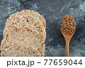 Airy crispbread and wooden spoon of raw buckwheat on marble surface 77659044