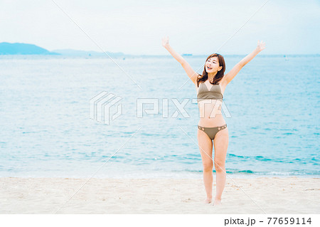 海辺でリラックスする水着の女性 海辺でリラックスする水着の女性 77659114